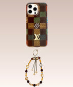 Multicolor checked iPhone case with a decorative wrist charm shown from another angle