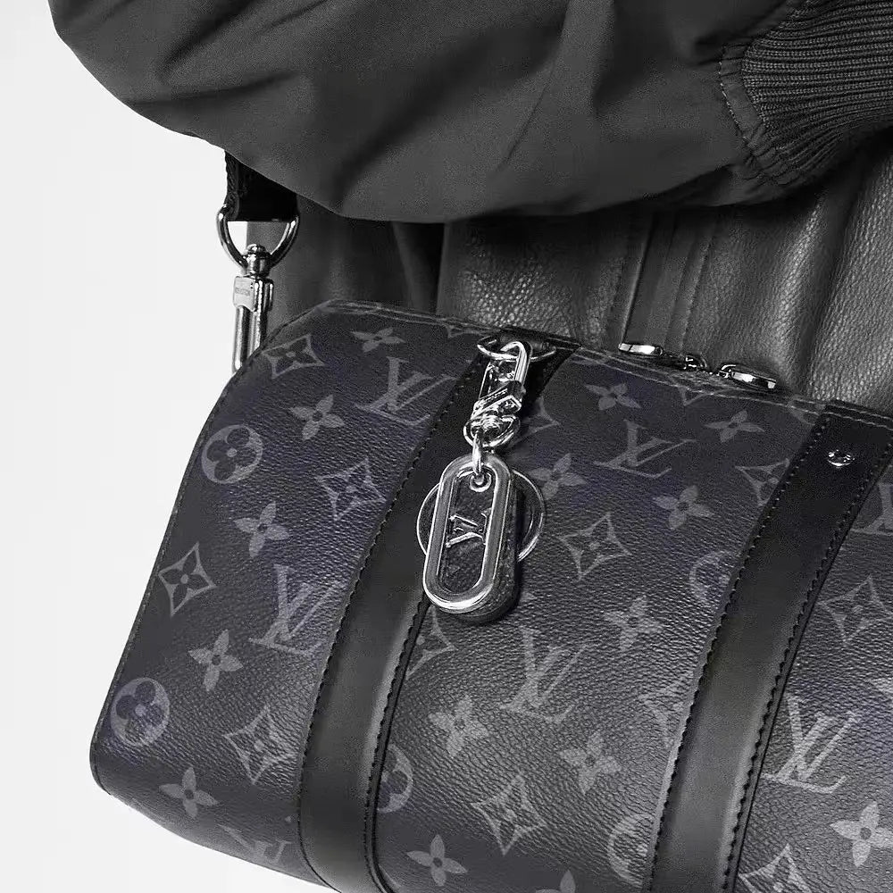 Dark loop keychain clipped to a monogram bag strap