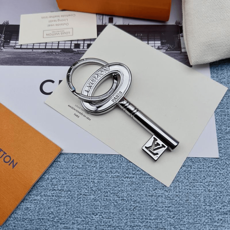Silver-tone key-shaped charm with oval head and LV detail