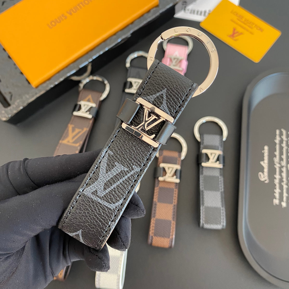 Black loop key holder with oversized gray monogram lettering