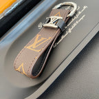 Angled view of brown monogram key holder and folded loop