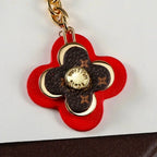 Close-up of red flower pendant with brown monogram center