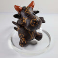 Brown monogram cow keychain with raised arms and reddish horns