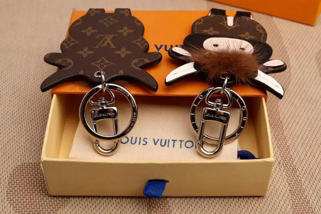 Front and back cow charms displayed together with metal hardware