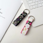 Black and white multicolor monogram key holders beside a keyboard