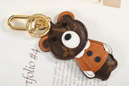 Angled view of bear charm with tan jacket and white paws