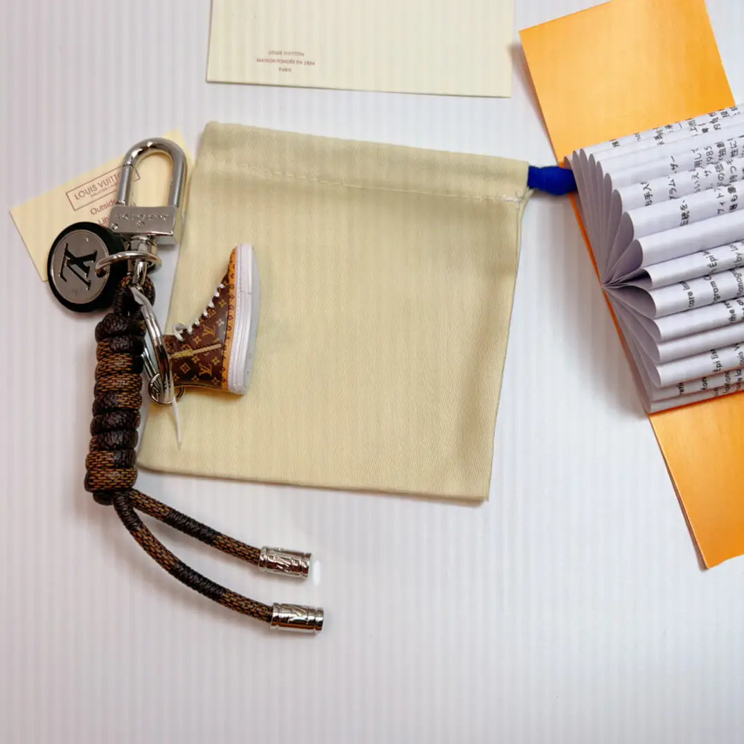 Brown sneaker keychain with matching braided cord on a fabric pouch