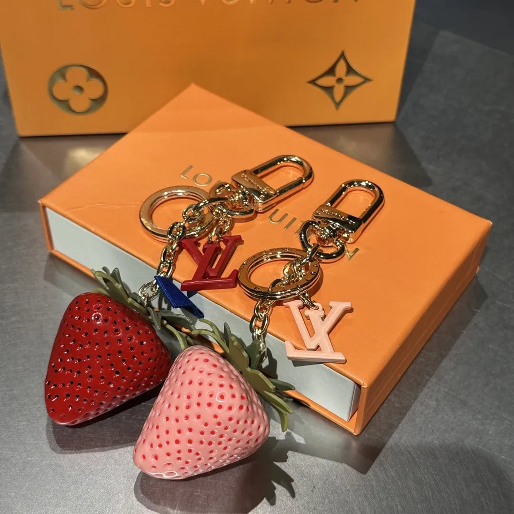Red and pink strawberry keychains with gold-tone hardware