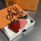Pink and red strawberry keychains arranged in an open box