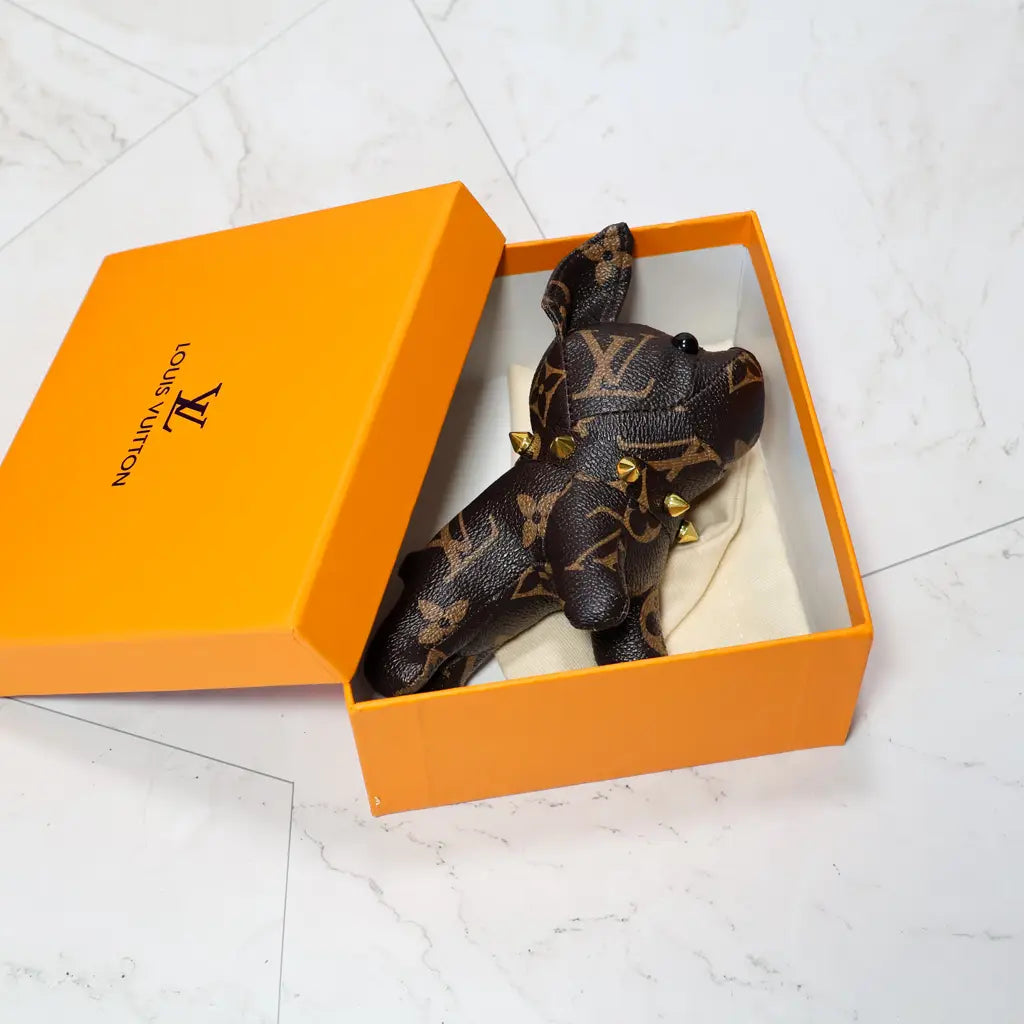 Brown monogram bulldog keychain resting inside an orange box