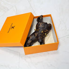Brown monogram bulldog keychain resting inside an orange box