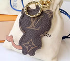 Reverse of cat charm showing brown monogram and curved tail