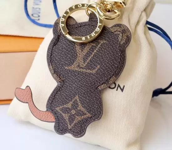 Reverse of cat charm showing brown monogram and curved tail