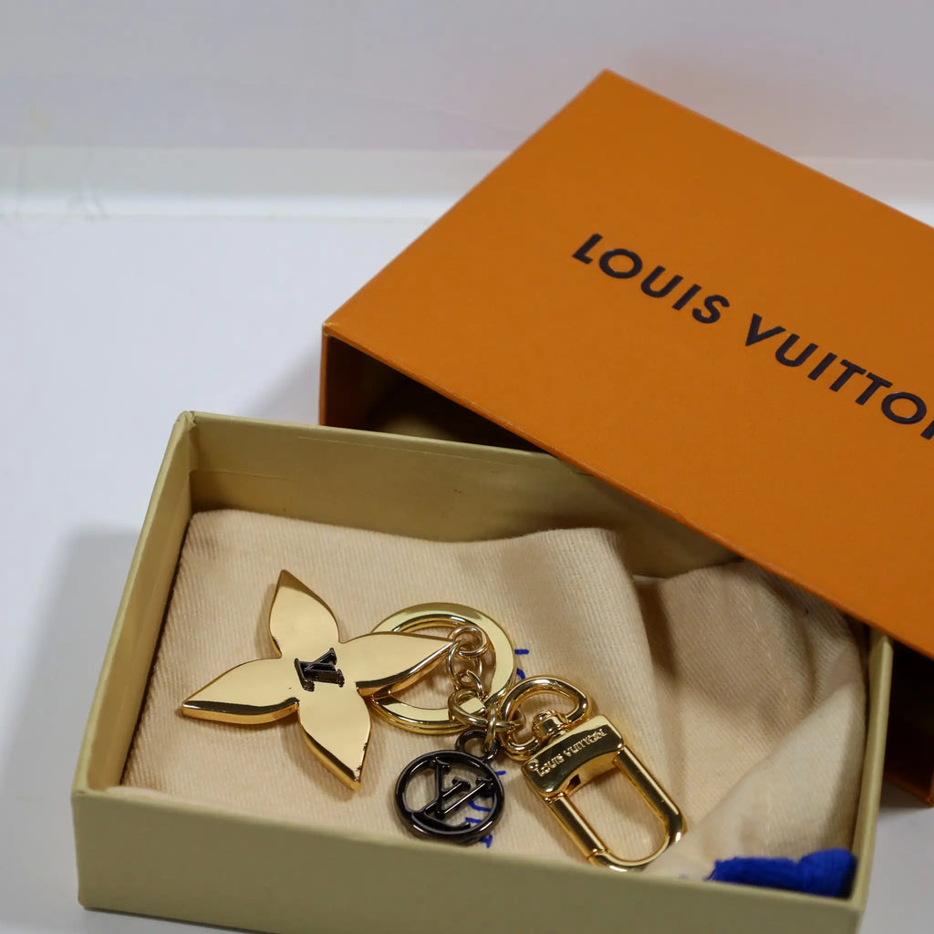 Flower keychain with black LV pendant inside an open box