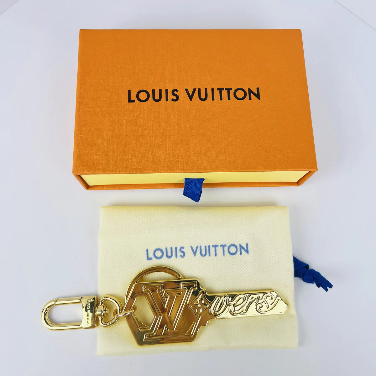 Gold-tone key charm displayed on a fabric pouch