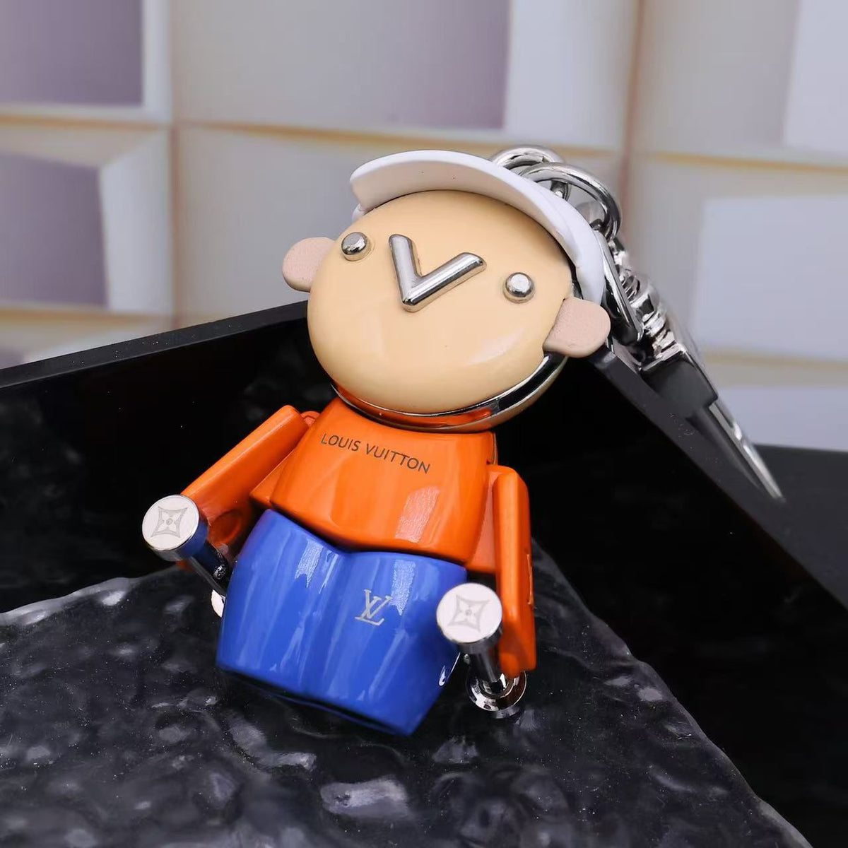 Orange-shirt character keychain showing silver-tone clasp behind its cap