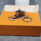 Brown miniature sneaker keychain with silver-tone ring on an orange box