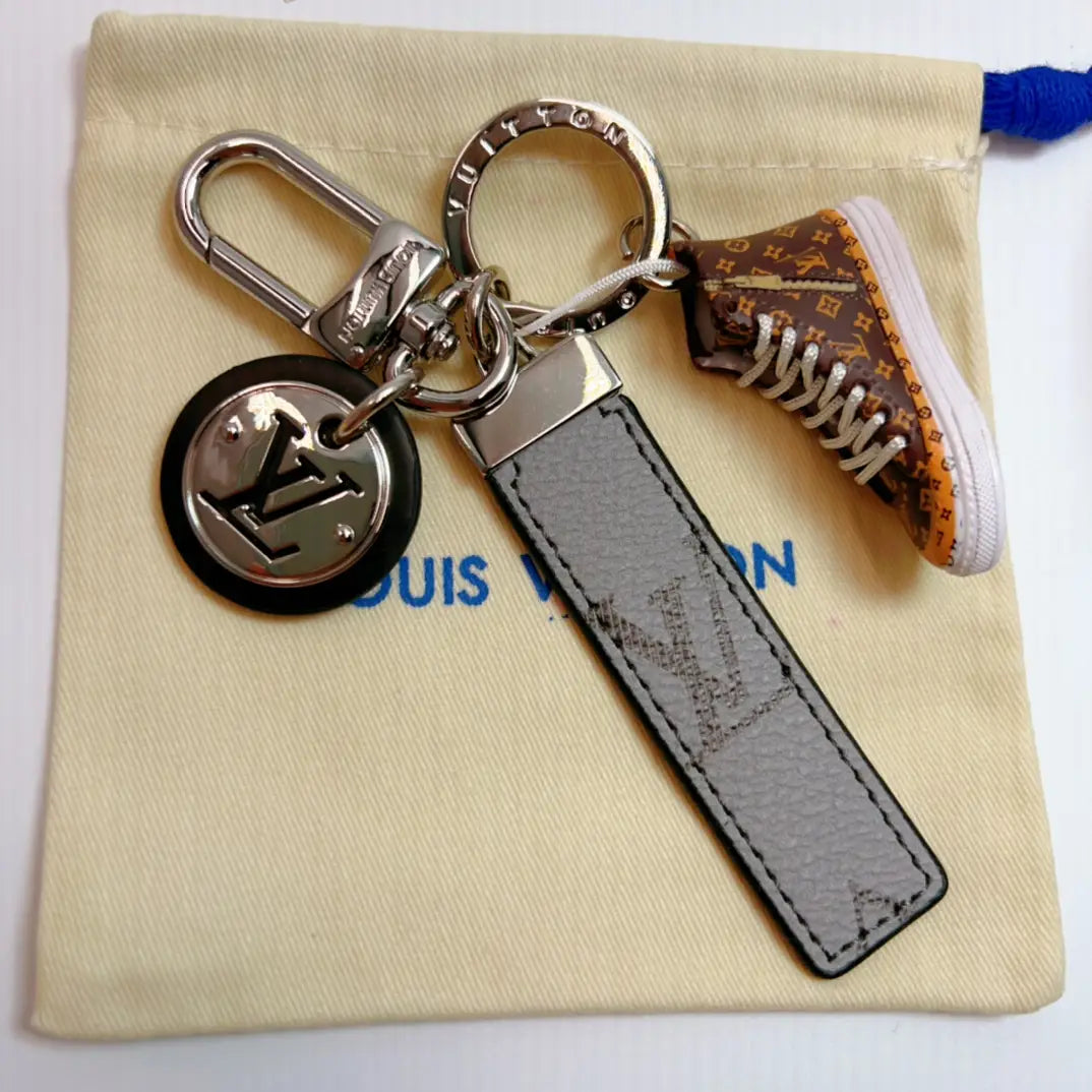 Brown sneaker keychain with gray monogram strap and round pendant