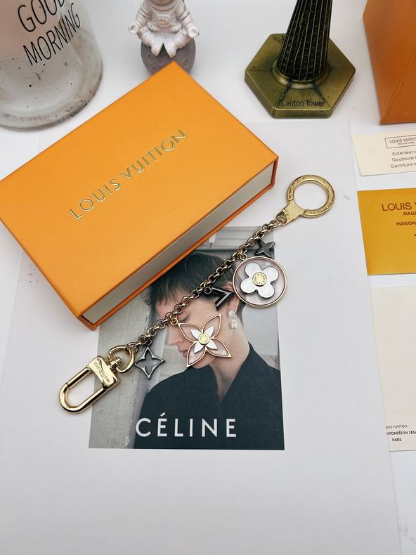 Flower ornament keychain displayed diagonally beside an orange box